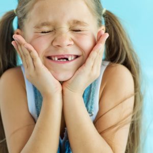 smiling girl with missing teeth